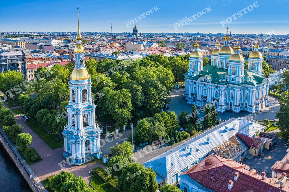 На фотографии запечатлён Никольский морской собор — один из красивейших барочных храмов Санкт-Петербурга, расположенный на набережной канала Крюкова. Золотые купола и изящная колокольня подчёркивают торжественность и изящество архитектуры. Вокруг собора простираются зелёные аллеи, создающие атмосферу спокойствия и умиротворения. Этот летний вид позволяет ощутить величие и гармонию одного из главных православных храмов города.